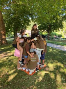 Schülerinnen und Schüler der Naturpark-Grundschule Dobel stehen gemeinsam auf einer kleinen Plane im Kurpark von Bad Herrenalb. Bei einem Teamspiel erleben sie, wie Zusammenarbeit und gegenseitige Rücksichtnahme funktionieren – ein anschaulicher Einstieg in das Naturpark-Modul „Lebensraum Bach“.